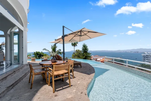 Hay una piscina y una mesa en el exterior, la vista de una de las casas de lujo